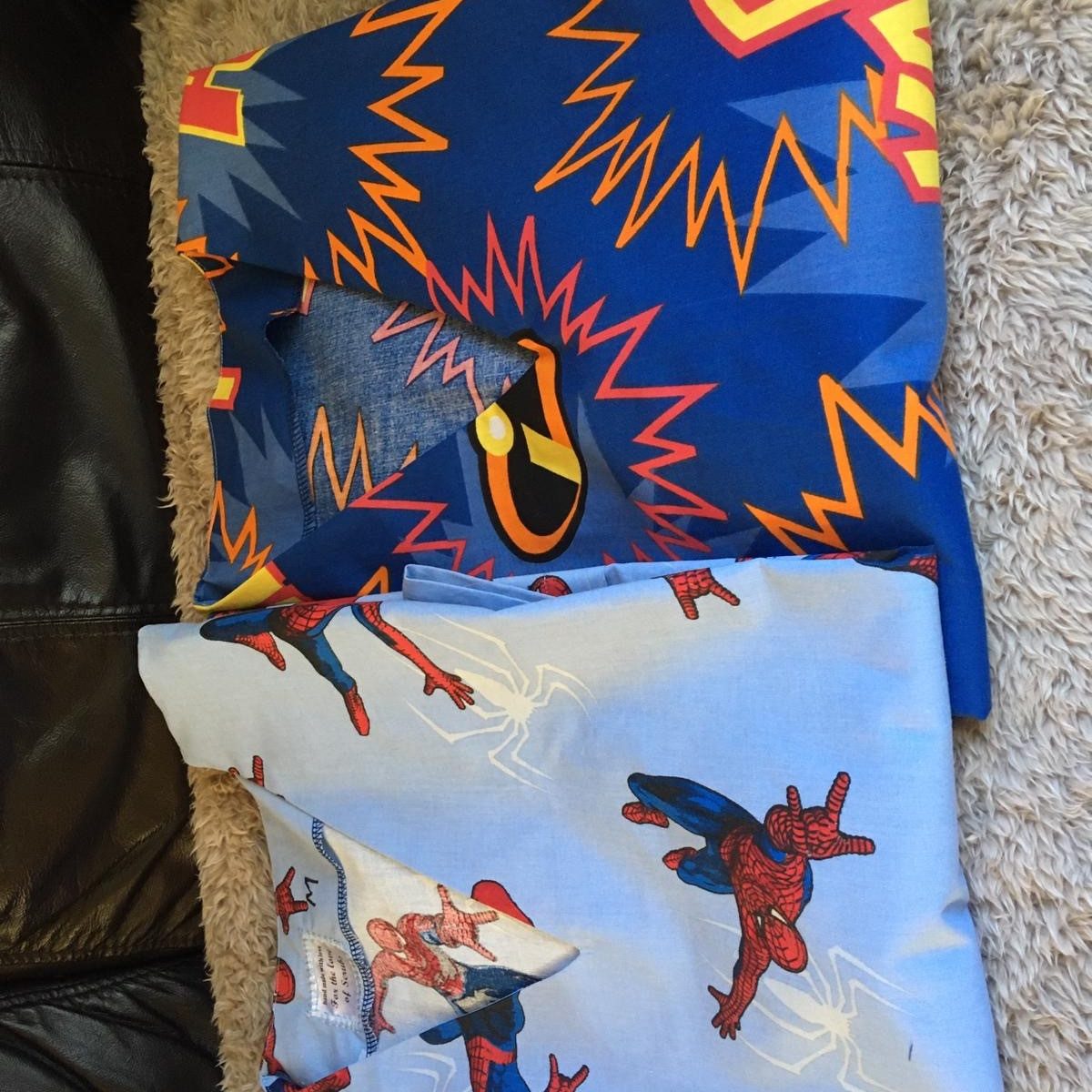 two sets of scrubs in bright superhero material