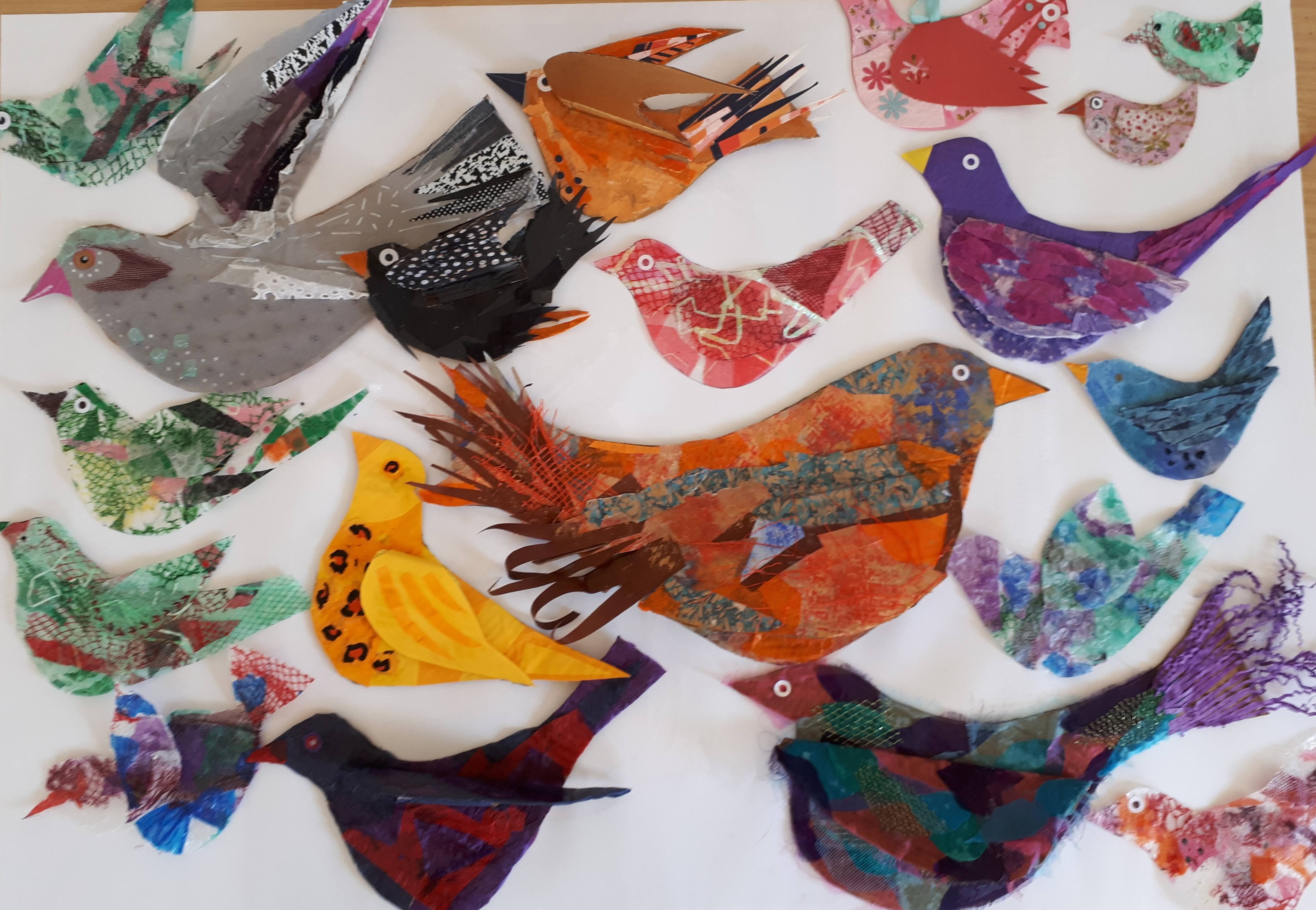 A selection of birds made at the York International Women's Week workshop laid out on a table.